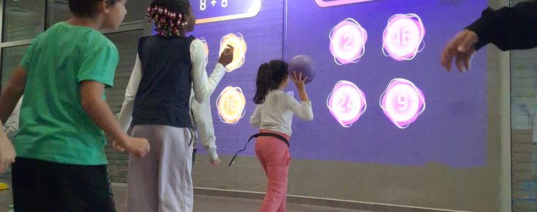 les eleves de CE1 lancent un ballon contre un mur interactif afin de réaliser un calcul de mathématiques.